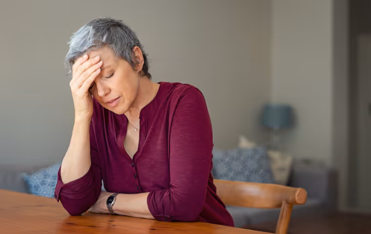 lady sitting at table with head in hands looking stressed