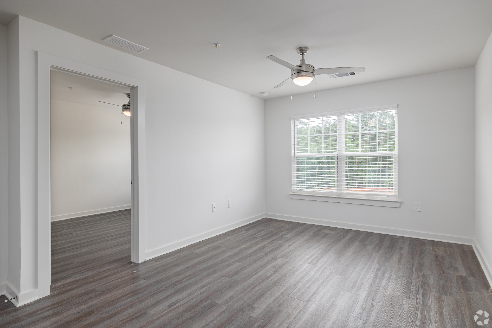 Unfurnished living room with large window and ceiling fan