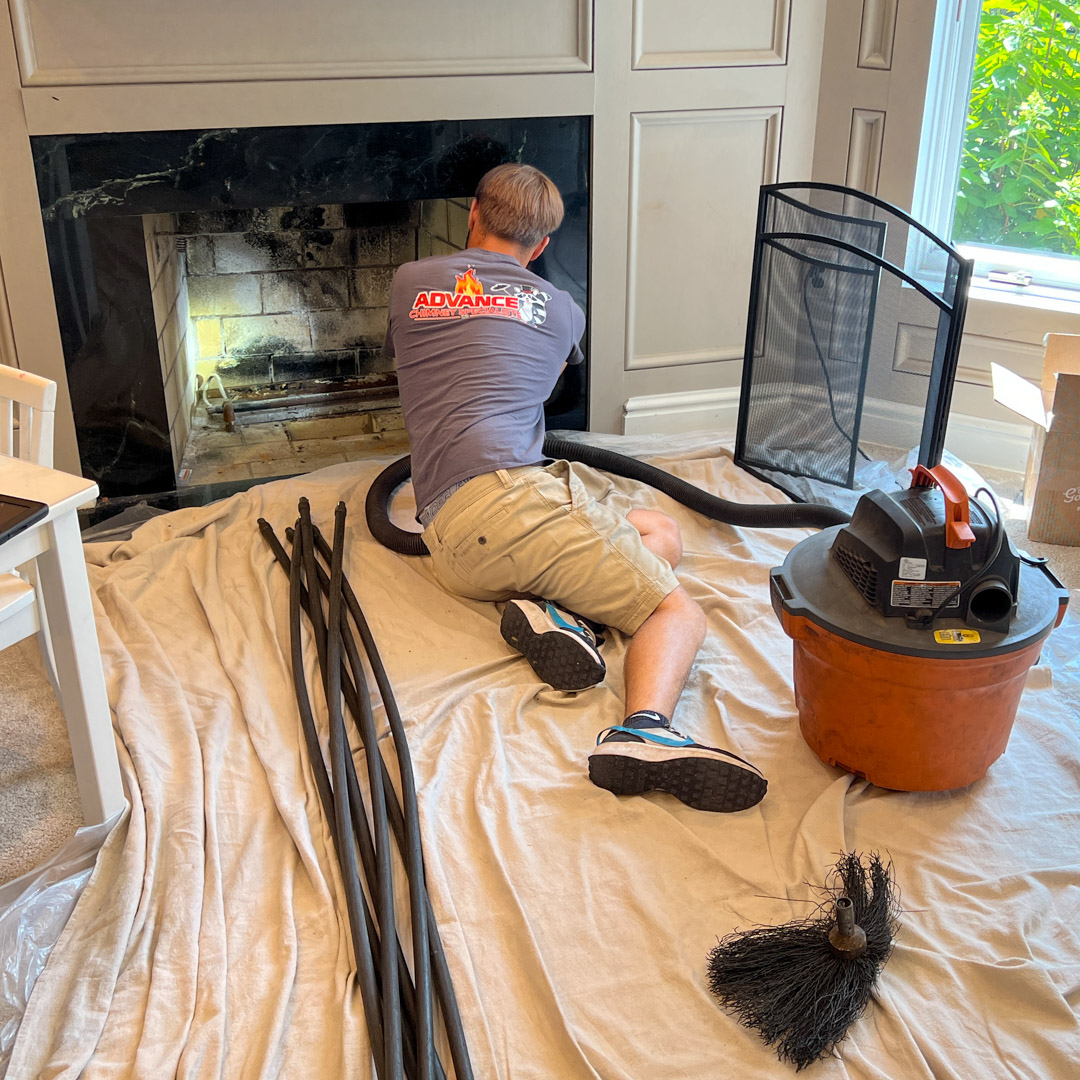 A Professional cleaning the fireplace with proper chimney cleaning kit