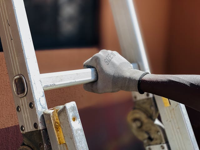 A professional worker climbing a ladder to start working
