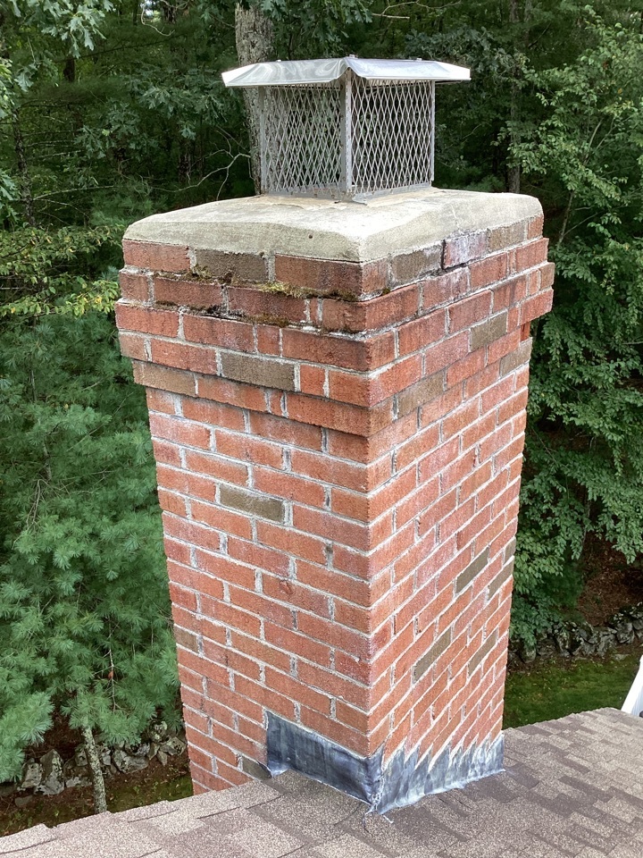 Undersized chimney cap on a cracked, deteriorating chimney crown