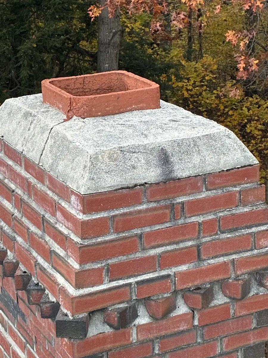 Before: uncapped clay flue on a weathered chimney crown in Westford, MA