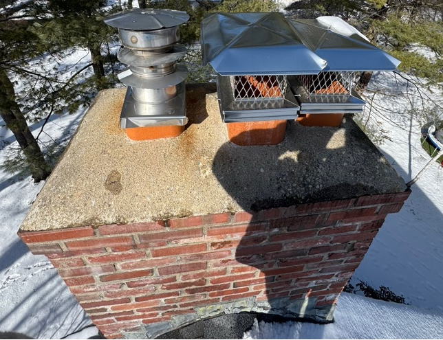 Chimney with a weathered, deteriorating crown in winter before repair