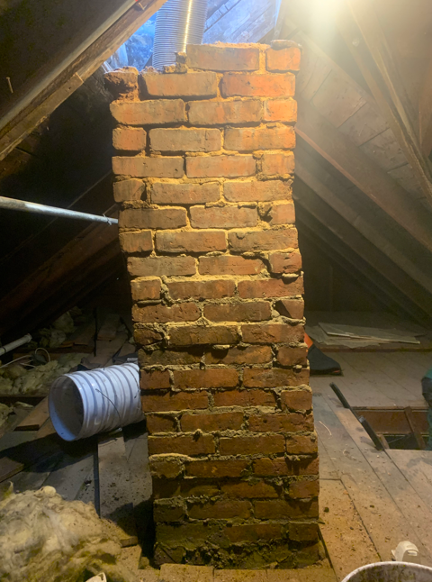 Attic chimney with crumbling mortar joints before repointing