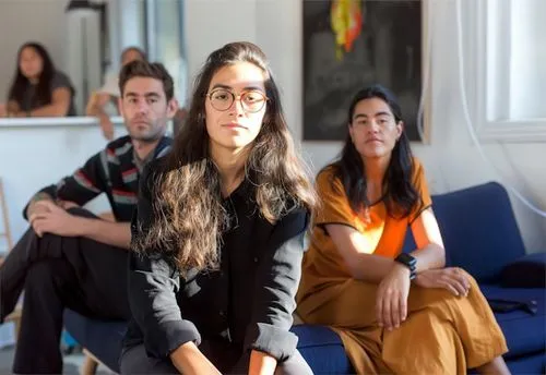 A group of people sitting on a couch in a living room.
