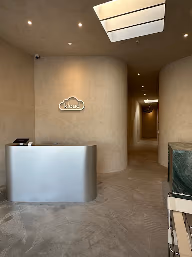 Earth-toned Kloud Health reception area in Beverly Grove, Los Angeles, featuring a lime-washed wall and a calm, minimalist aesthetic.