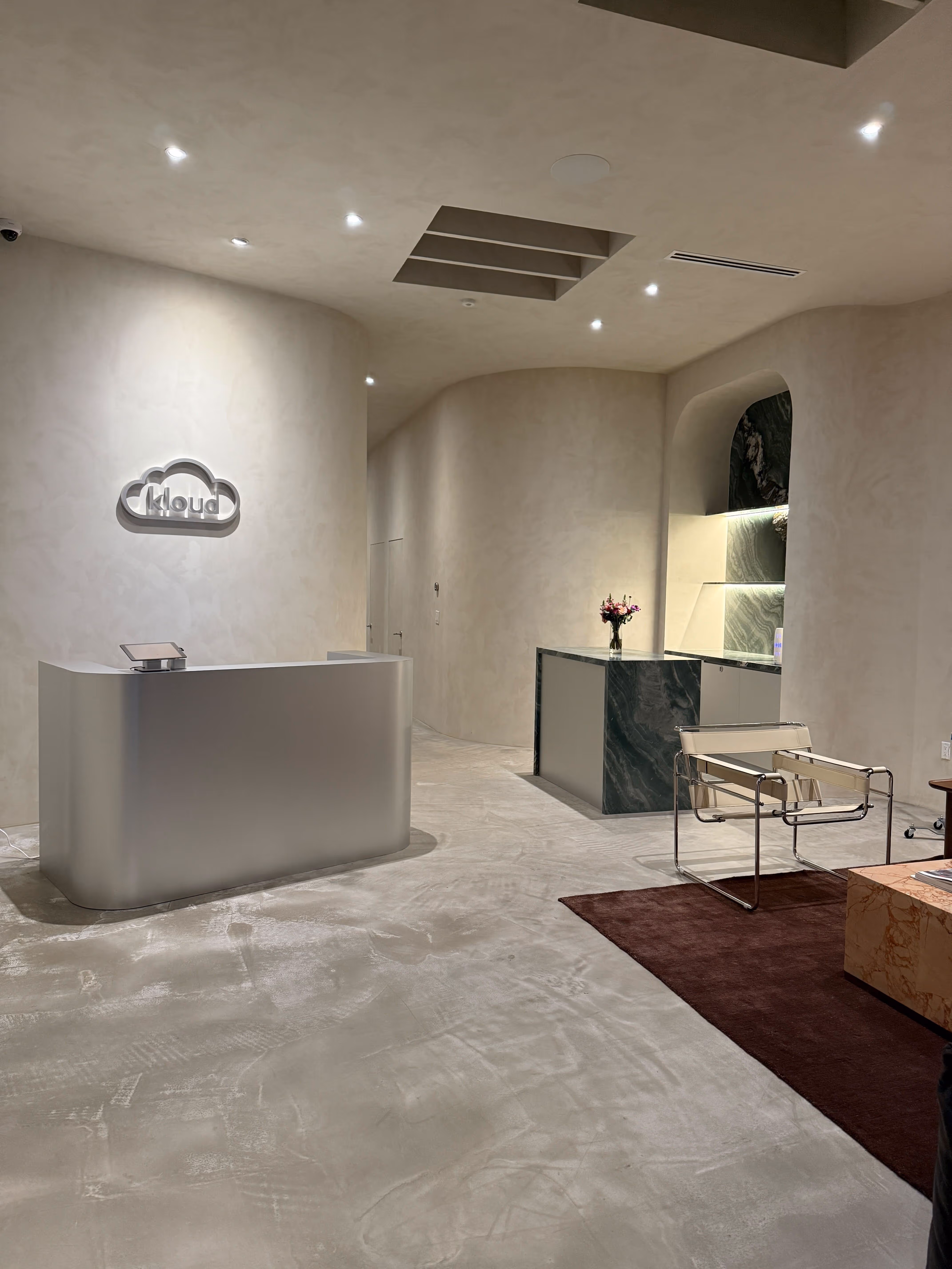 Earth-toned Kloud Health reception area in Beverly Grove, Los Angeles, featuring a lime-washed wall and a calm, minimalist aesthetic.
