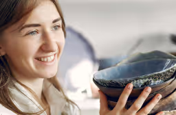 woman holding a bowl smiling off camera