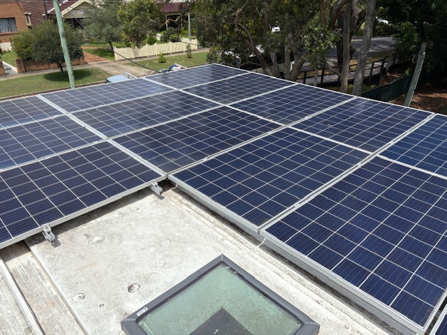 Cleaned solar panels on a flat roof with a skylight in the foreground