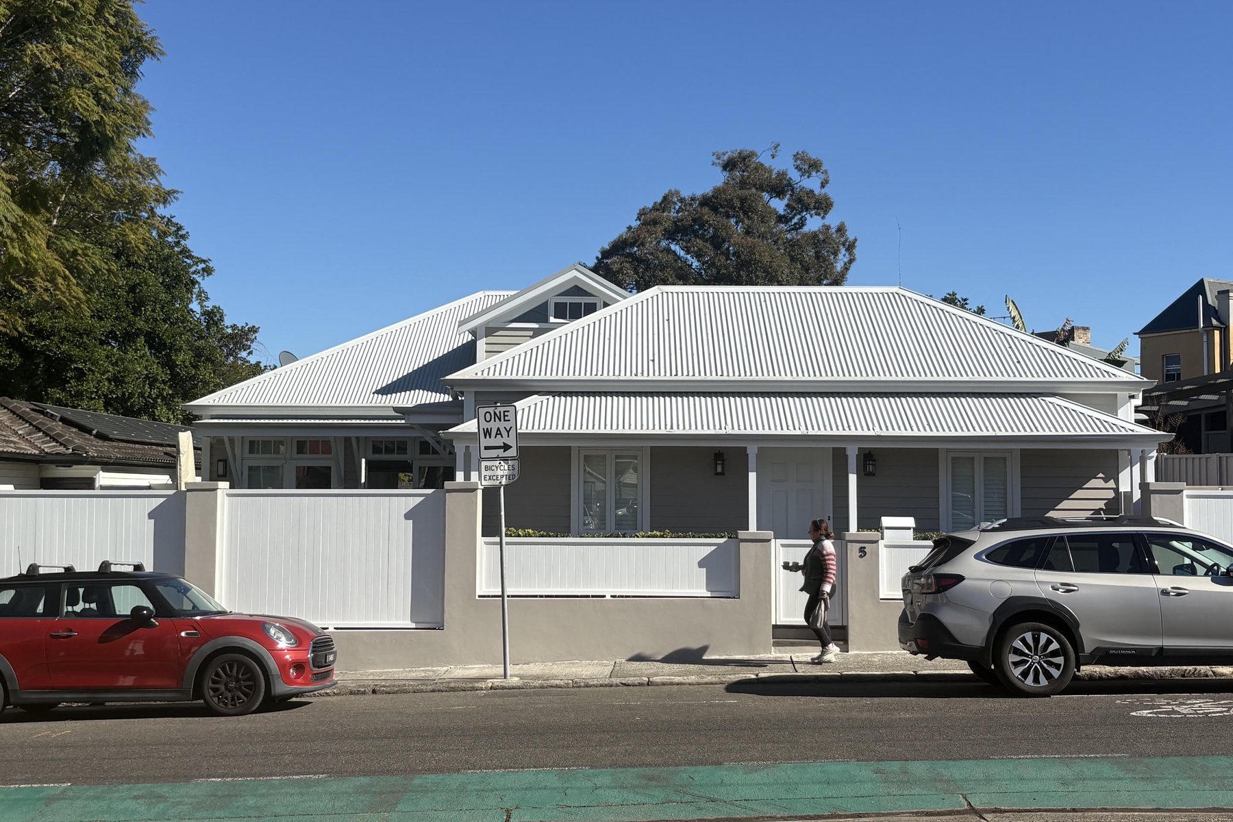 Clean street frontage of a weatherboard Sydney home with white fence and metal roof, presented ready for sale.
