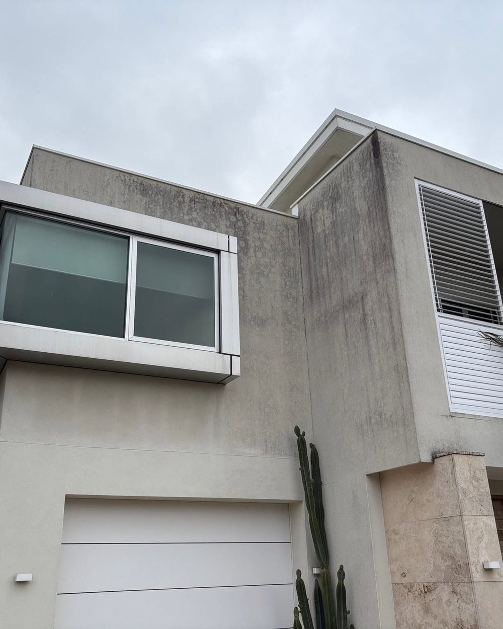 Rendered exterior wall of a Sydney home marked with mould and weathering before soft washing.