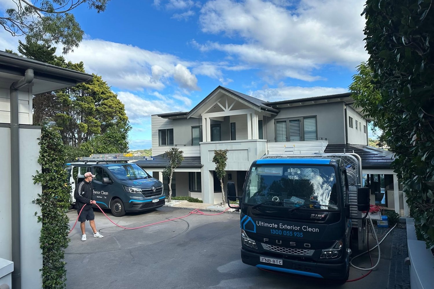 Two Ultimate Exterior Clean vehicles set up outside a large Sydney home for a full pre-sale exterior clean.