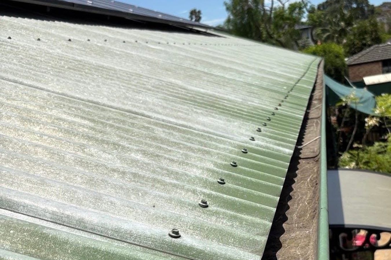The same corrugated roof gutter cleared of debris after vacuum gutter cleaning.