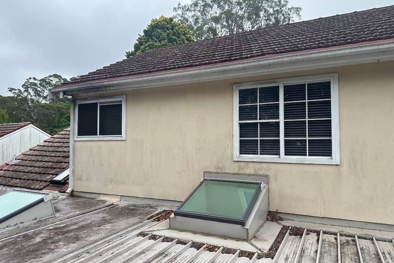 Rendered exterior wall of a Sydney home streaked with dirt and weathering before soft washing.
