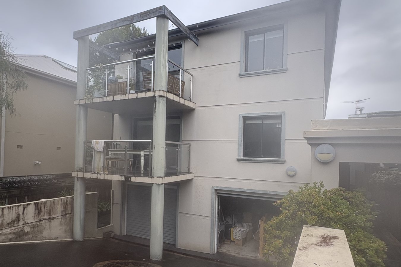 Rendered apartment building in Sydney being soft washed, with the surface still wet.