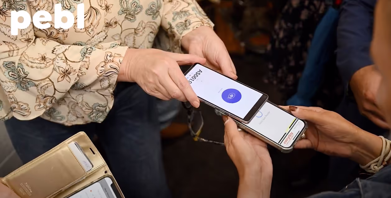 A person uses a mobile phone to complete a contactless payment with another mobile device, demonstrating the secure and convenient features of mobile invoicing.