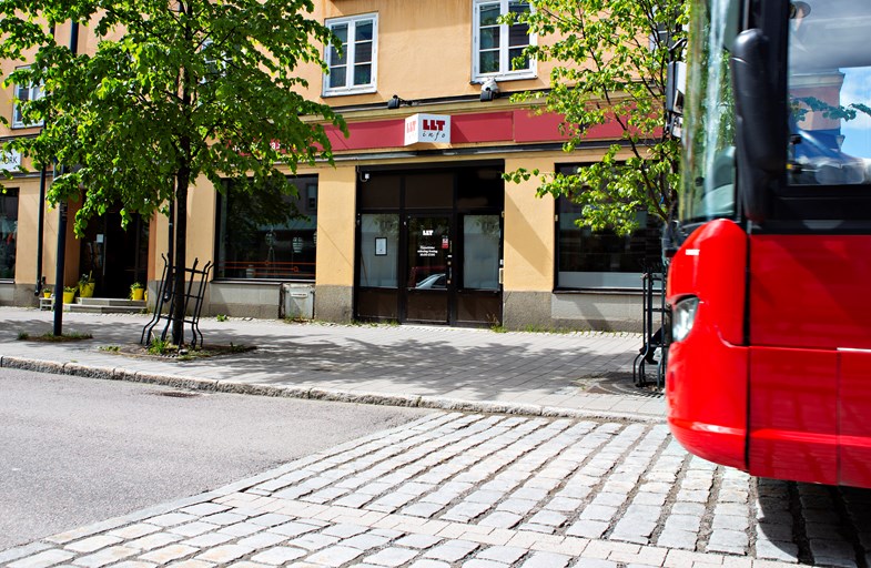 Bild på fasad och ingång till LLT info. Fronten av en buss syns också i bilden.