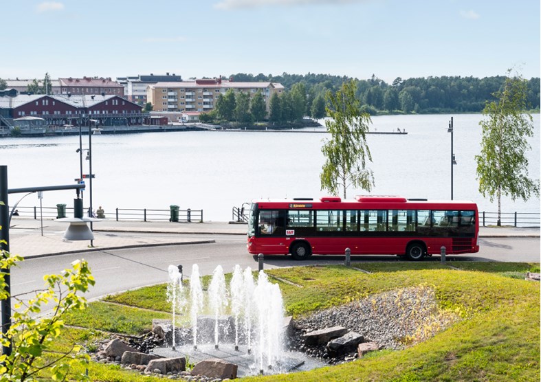 en buss körande längs en väg vid vattnet