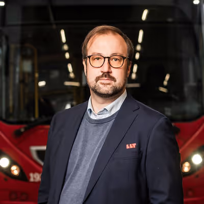 Bild på Jonas Vinblad von Walter framför en röd LLT buss