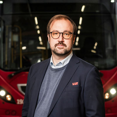 Bild på Jonas Vinblad von Walter framför en röd LLT buss