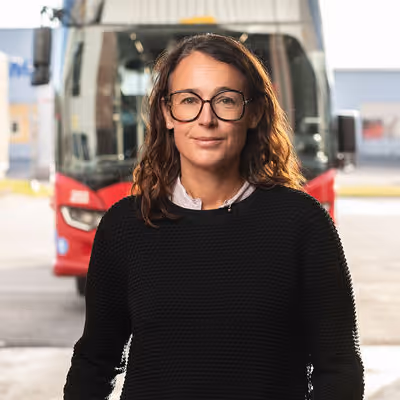 Bild på Anna Kowal Lindbäck framför en röd LLT buss