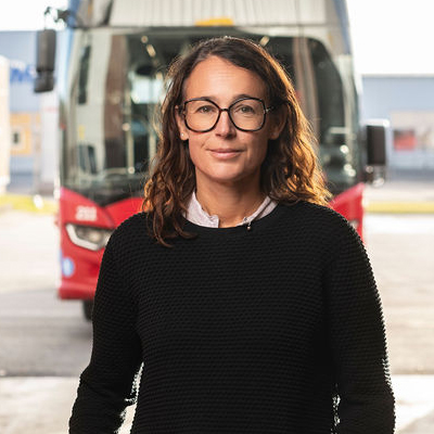 Bild på Anna Kowal Lindbäck framför en röd LLT buss