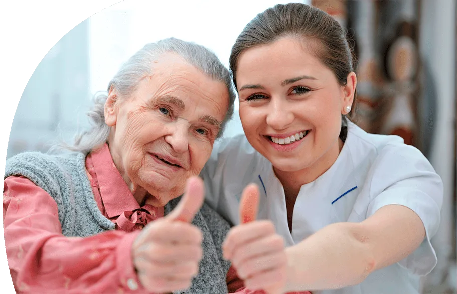 Eine Frau mit langen blonden Haaren und auffällig grünem Hemd steht mit dem Rücken zur Kamera und hält vor einer Gruppe junger Erwachsener einen Vortrag. Die Teilnehmenden sitzen in einem hellen Raum mit großen Fenstern, tragen weiße T-Shirts und wirken aufmerksam und interessiert.