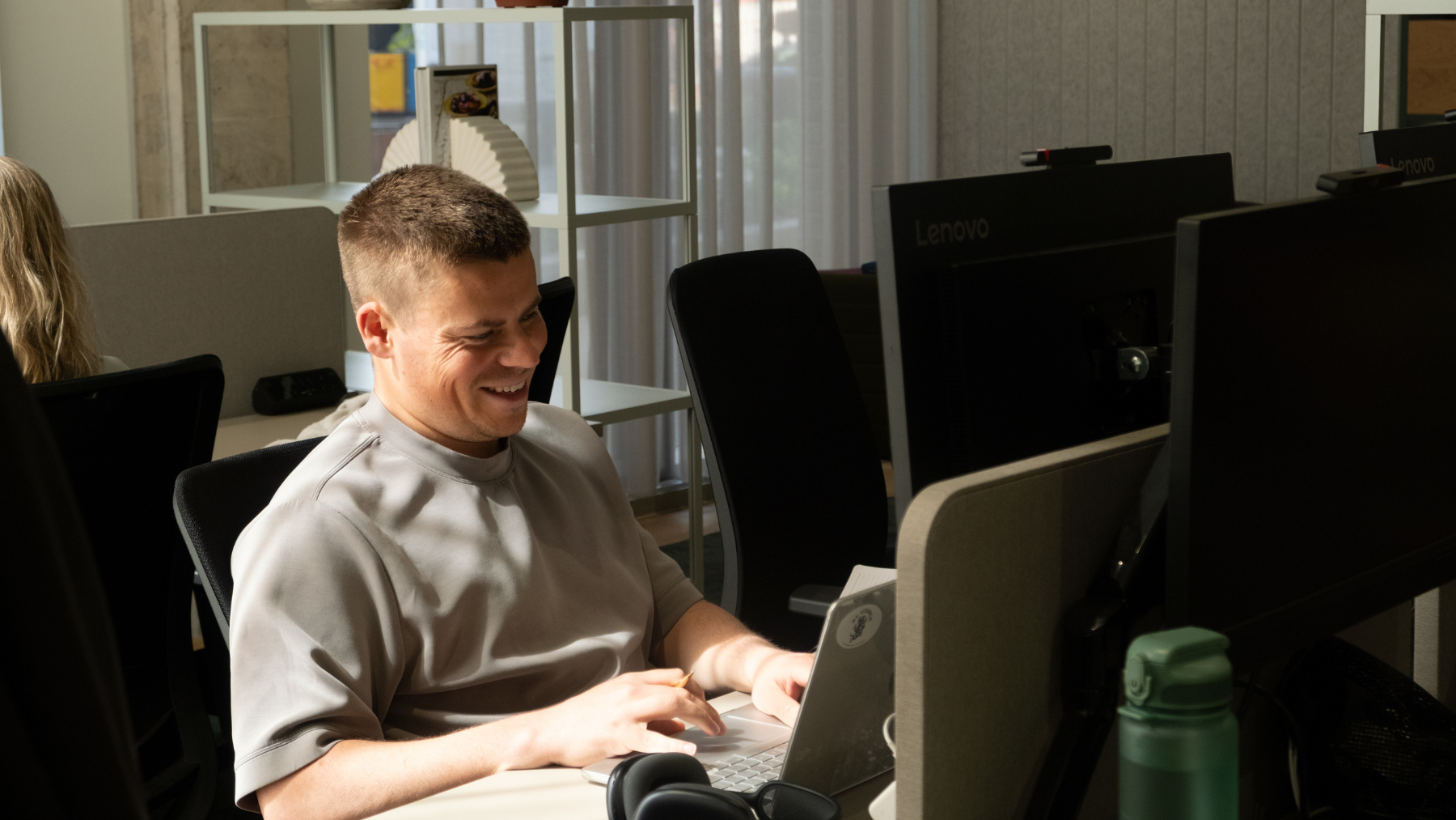 A man sat at a table working on a laptop
