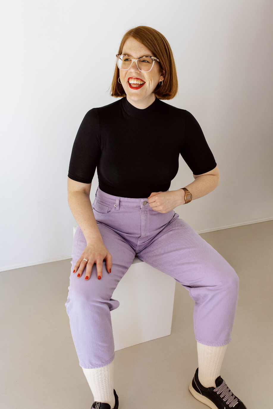 Stillberaterin Chrissi sitzt auf einem Stuhl und lacht