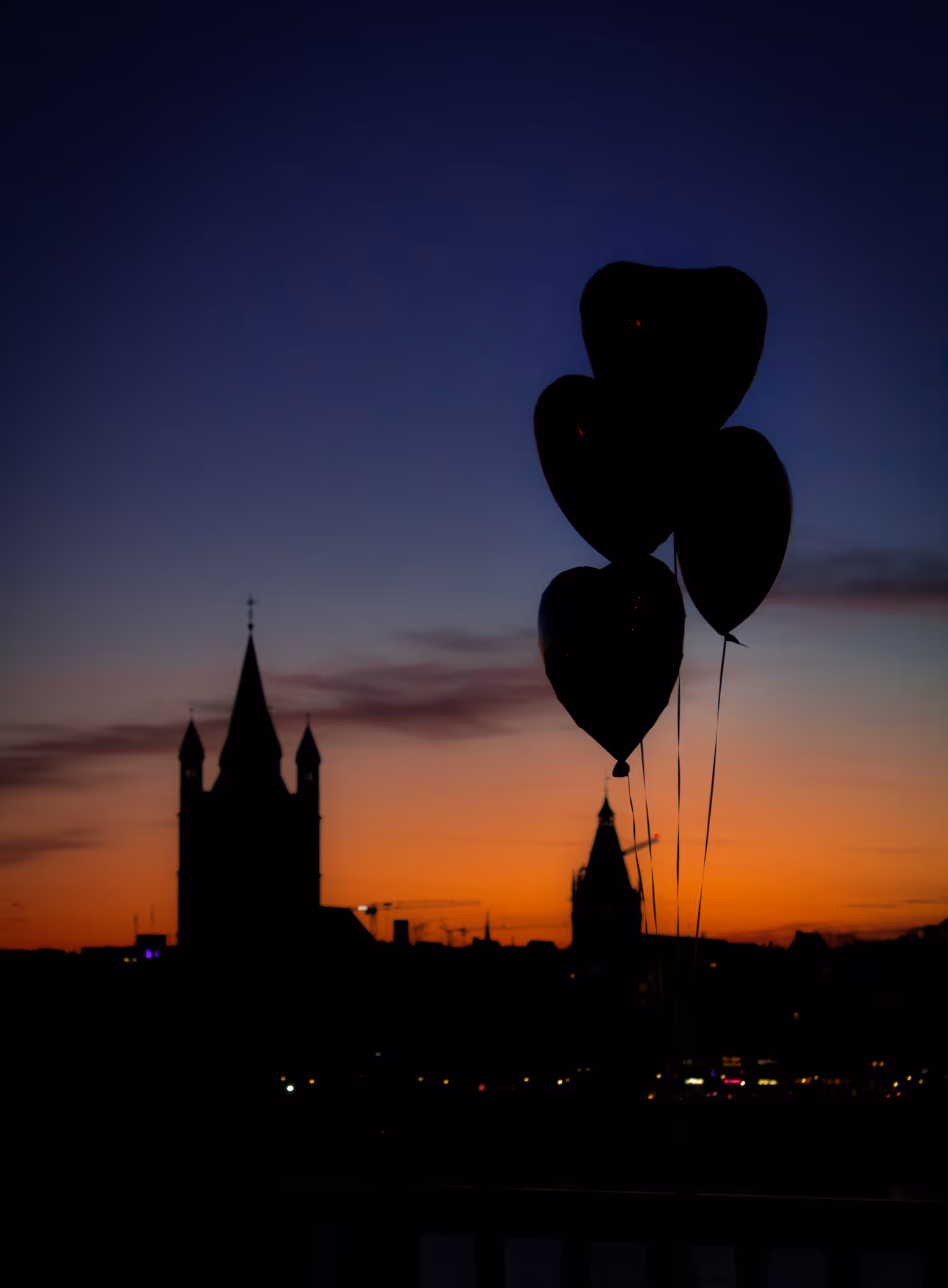 Herzluftballons vor der Skyline von Köln zum Sonnenuntergang