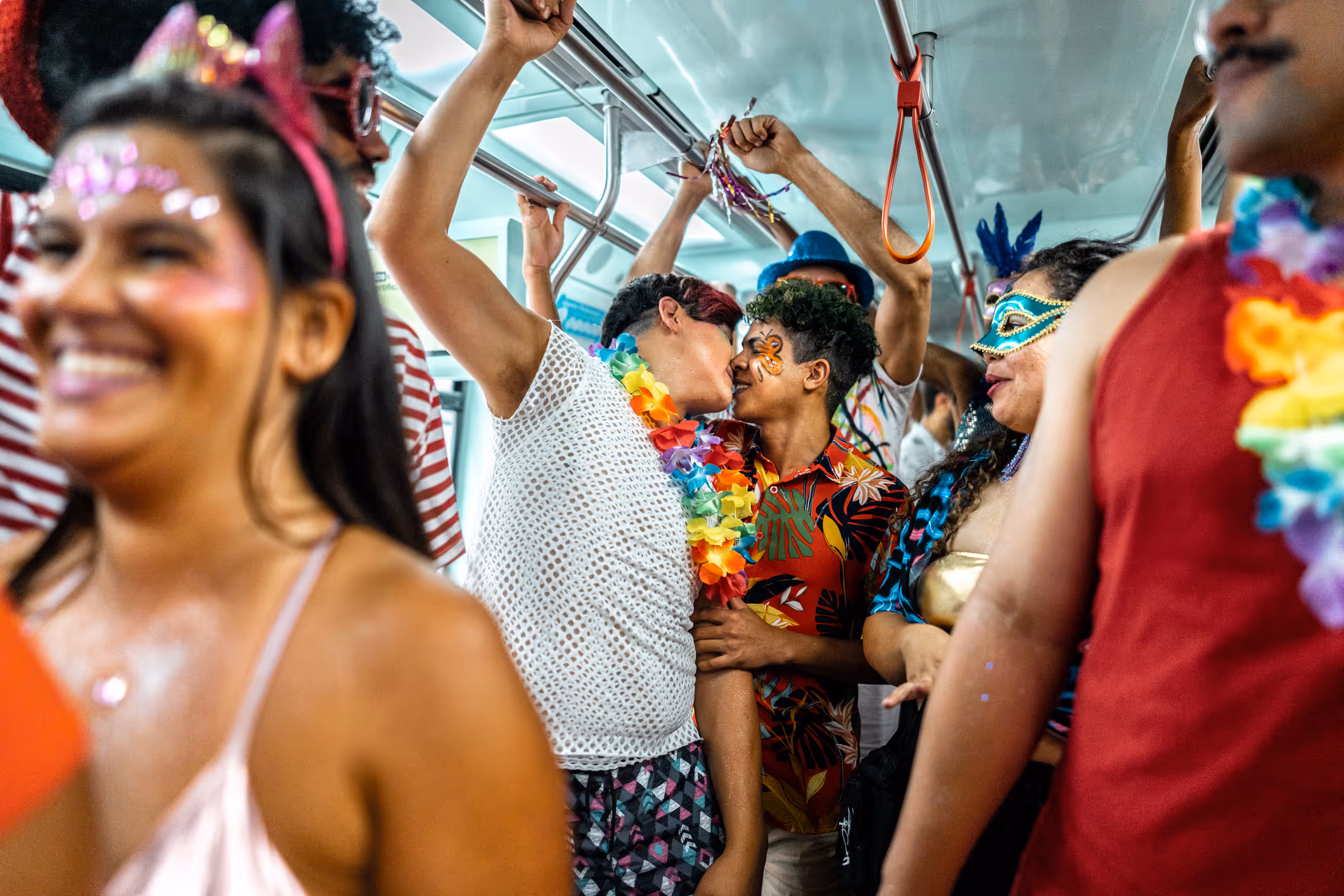 Schwules Paar küsst sich und feiert Karneval in der U-Bahn