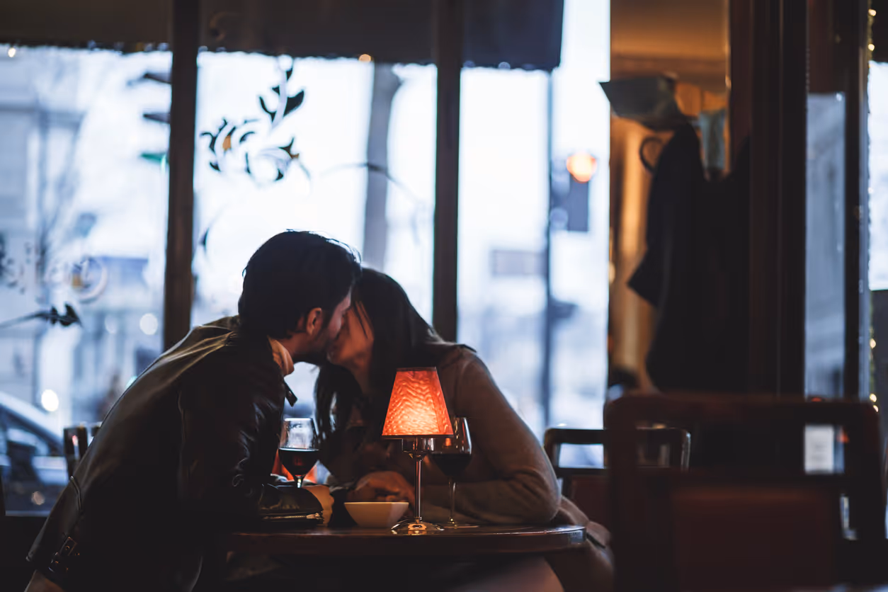 Ein Paar küsst sich in einem romantischen Café