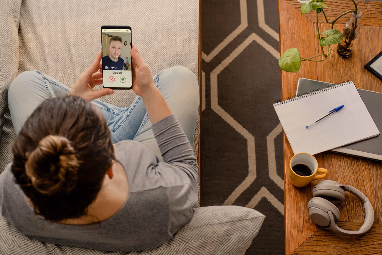 Eine Frau schaut auf ihrem Smartphone ein Dating-Profil an