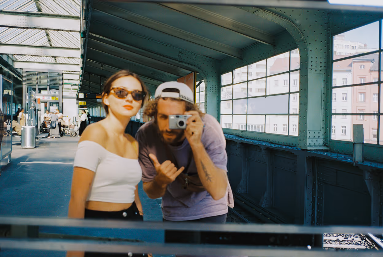 Ein Paar macht mit einer Digitalkamera ein Selfie in einer U-Bahn-Station
