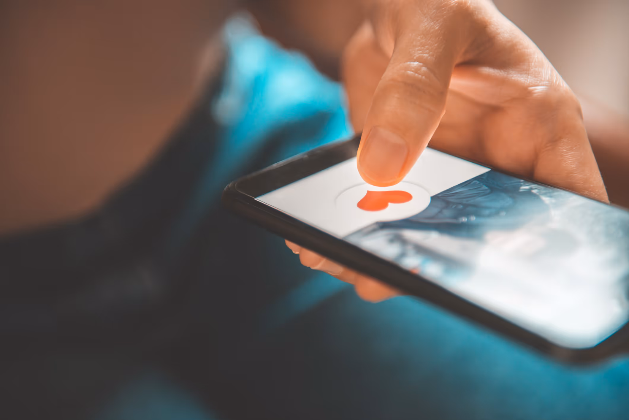 Finger einer Frau, die auf dem Smartphone auf das Herz in einer Dating-App drückt