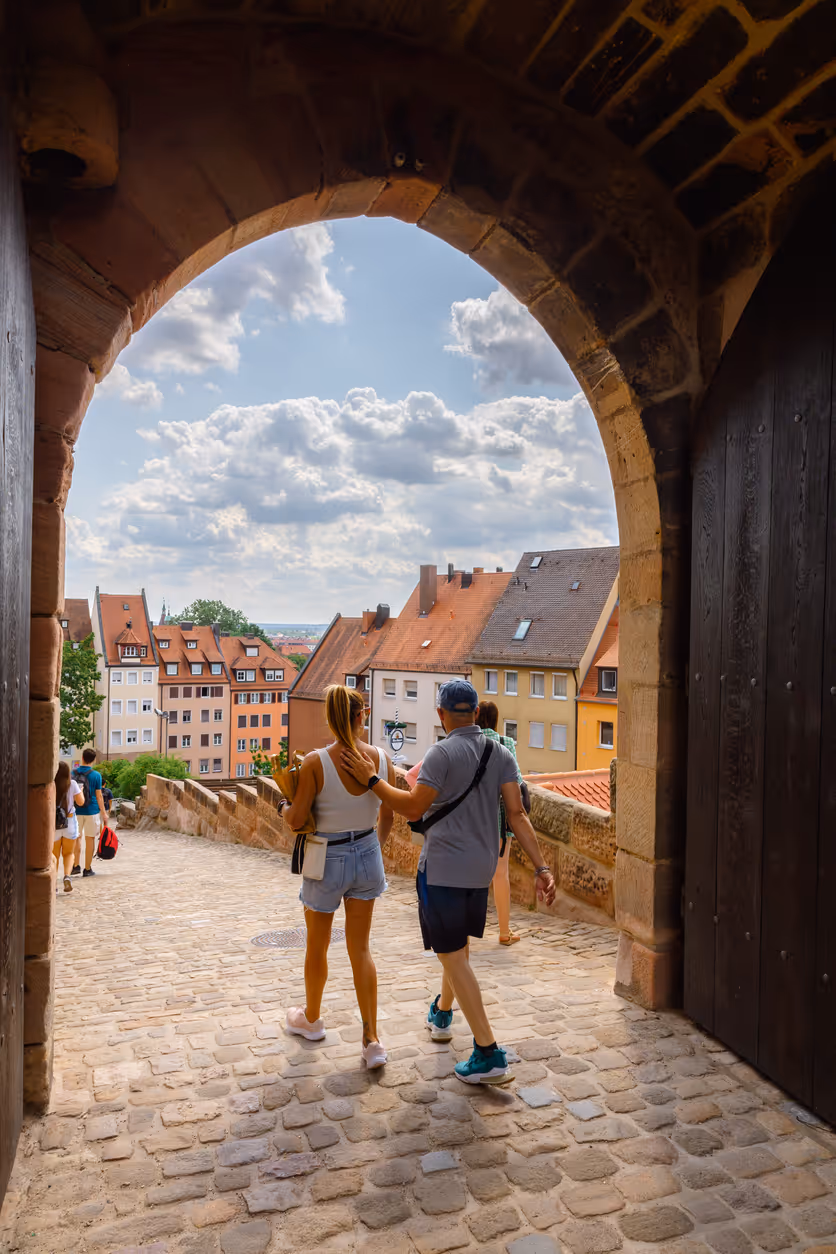Touristen spazieren durch gepflasterte Straßen der Nürnberger Burg