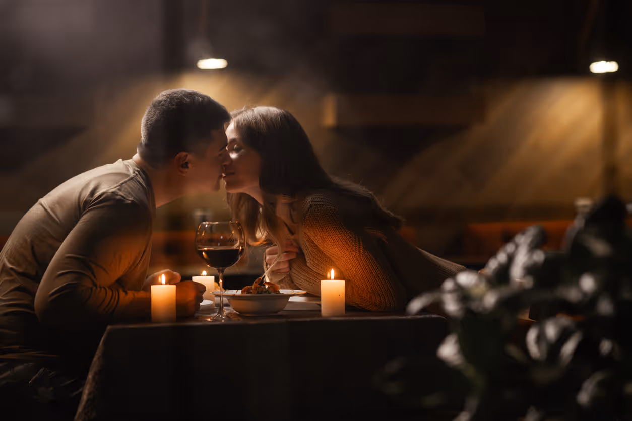 Verliebtes Paar küsst sich beim  romantischen Abendessen