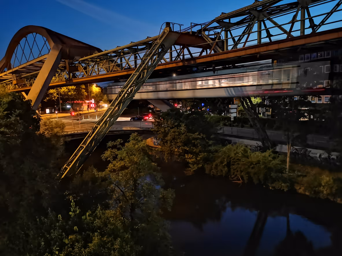 Die Schwebebahn in Wuppertal über der Wupper am Abend.