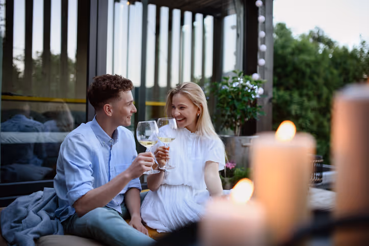 Paar stößt auf dem Balkon mit Weißwein an