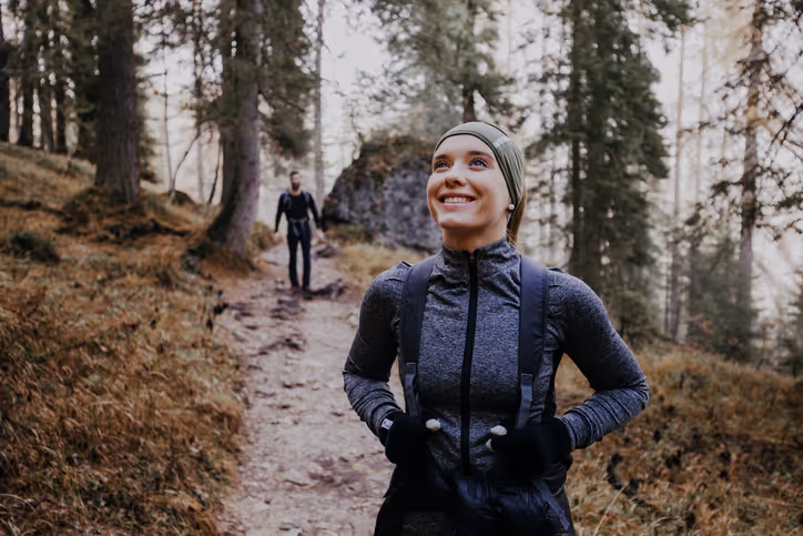 Junge Frau und Partner beim Wandern durch den Wald. 