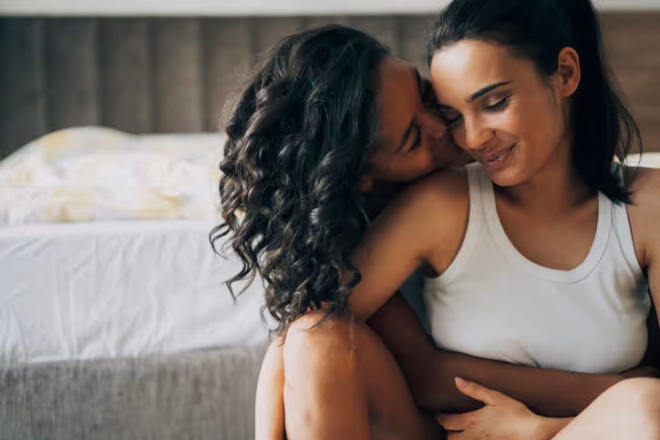 Zwei Frauen umarmen sich innig und lächeln