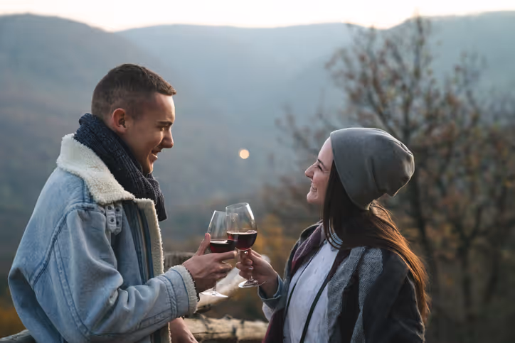 Mann und Frau trinken Wein bei einem Date mit Ausblick in die Natur