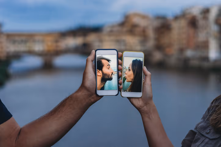 Paar hält seine Handys und zeigt Selfies mit ähnlichen Posen vor einer historischen Kulisse