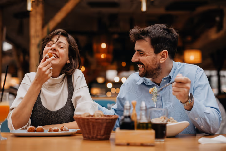 Lachendes Paar im Restaurant bei einem gemeinsamen Essen