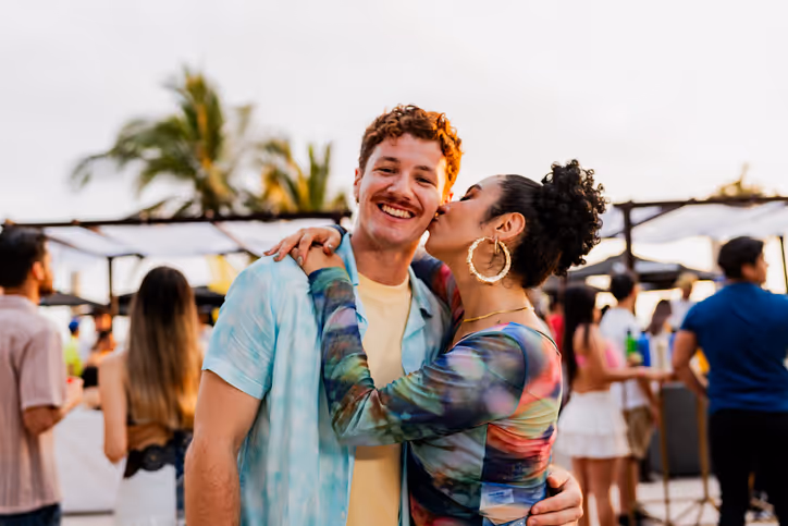 Fröhliches Paar auf einer Veranstaltung im Freien, das sich entspannt und glücklich umarmt