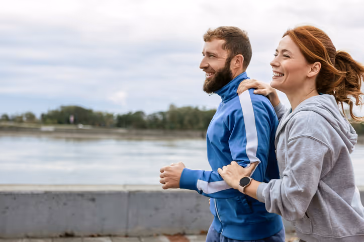 Ein Paar joggt gemeinsam am Flussufer entlang