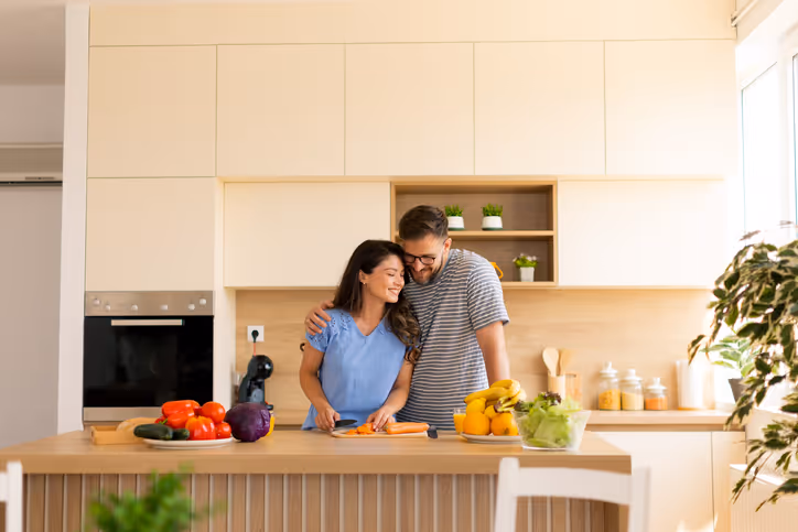  Ein Paar steht in der Küche und schneidet gemeinsam Gemüse