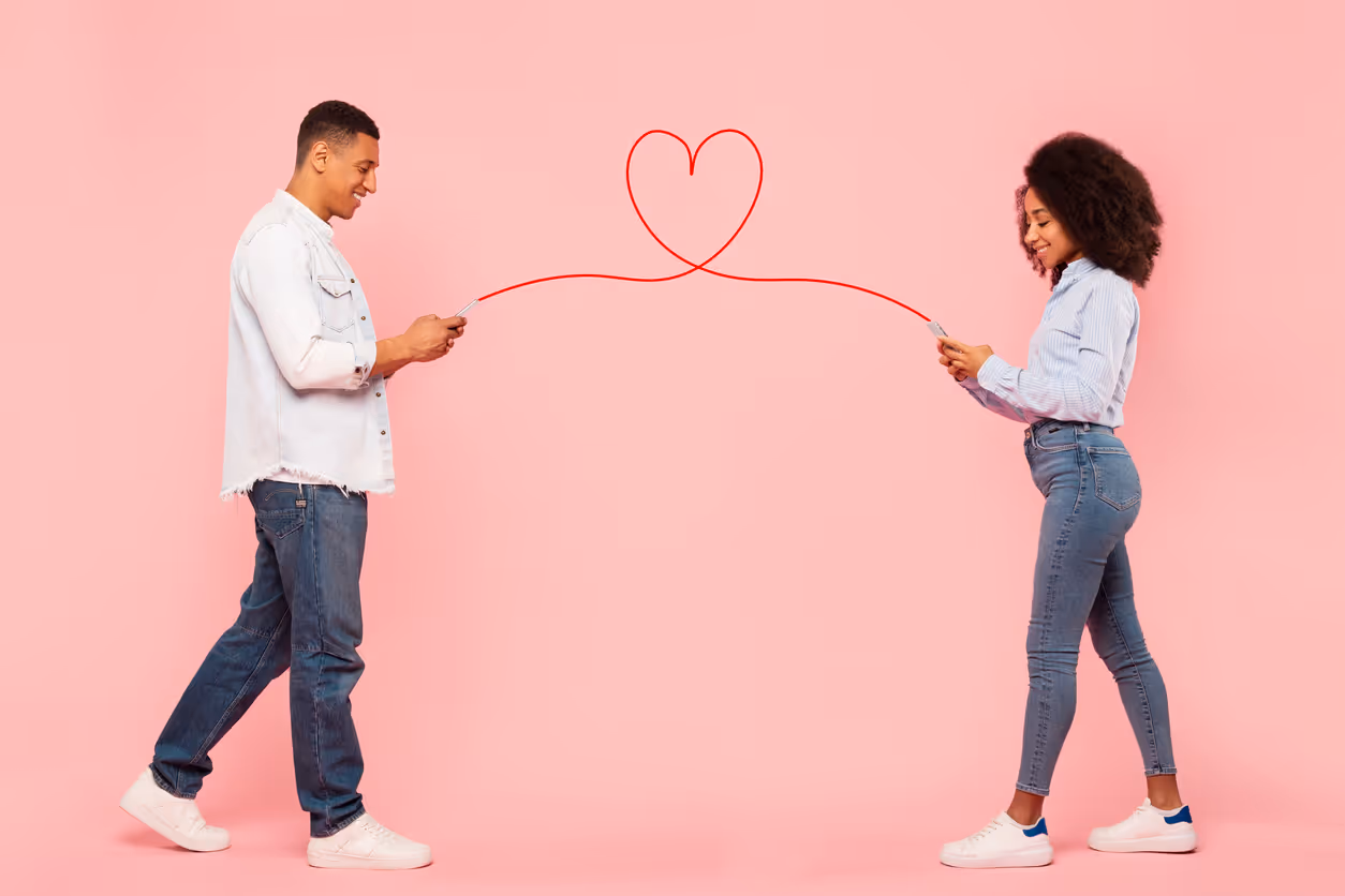 Zwei Personen mit Smartphones stehen sich gegenüber, eine gezeichnete Linie bildet ein Herz zwischen ihnen