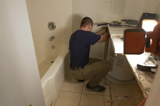 The vanity cabinet removed, exposing the water heater that had been sealed in behind it