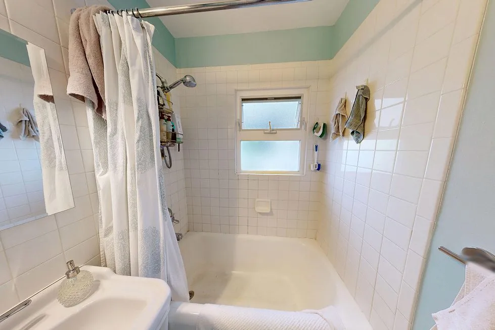 Before: a 1928 Capitol Hill condo bathroom with a step-over tub and pedestal sink
